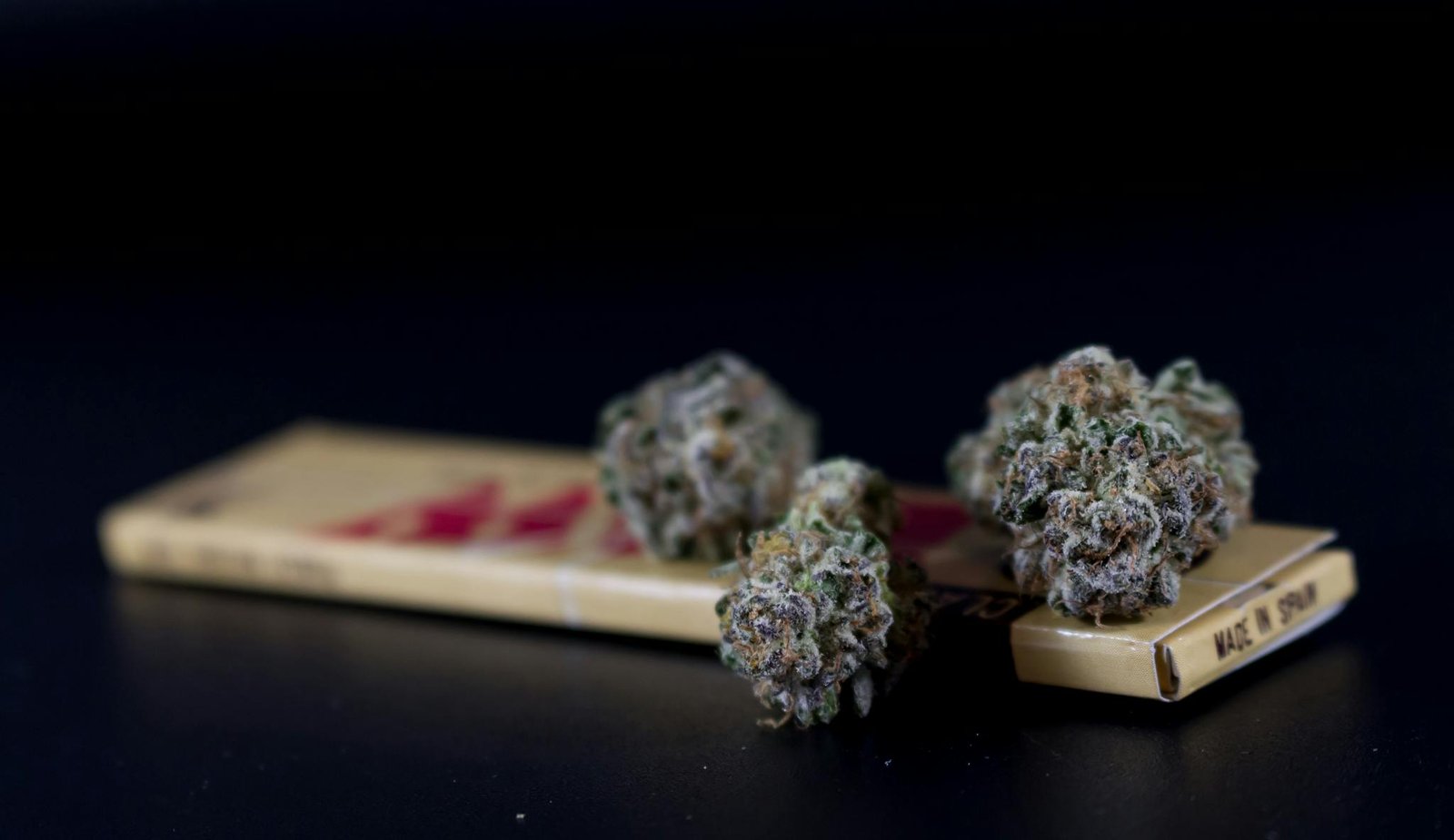 Close-up of cannabis buds on a rolling papers box, ideal for alternative medicine themes.